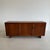The 'MB15' Sideboard with three doors, two compartments with one shelf each, and one compartment with three flat pull-out...