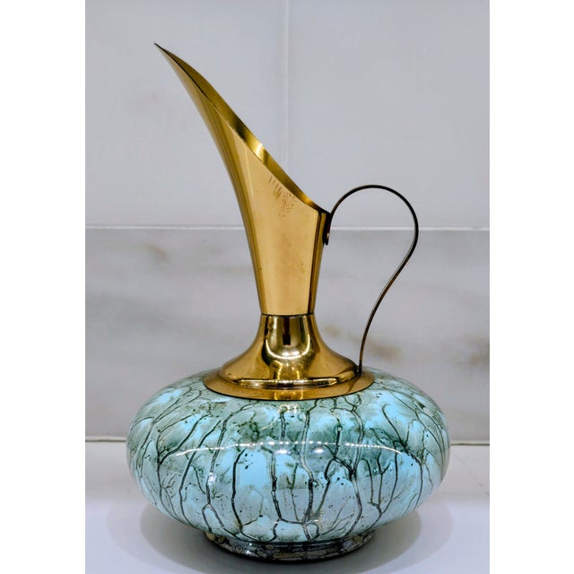 Hand-painted Delft Holland ewer vase featuring a polished brass neck and elongated spout over a rounded aqua glass body...