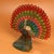 This striking sculpture depicts a peacock with its tail feathers fully fanned in a classic display pose, a traditional...