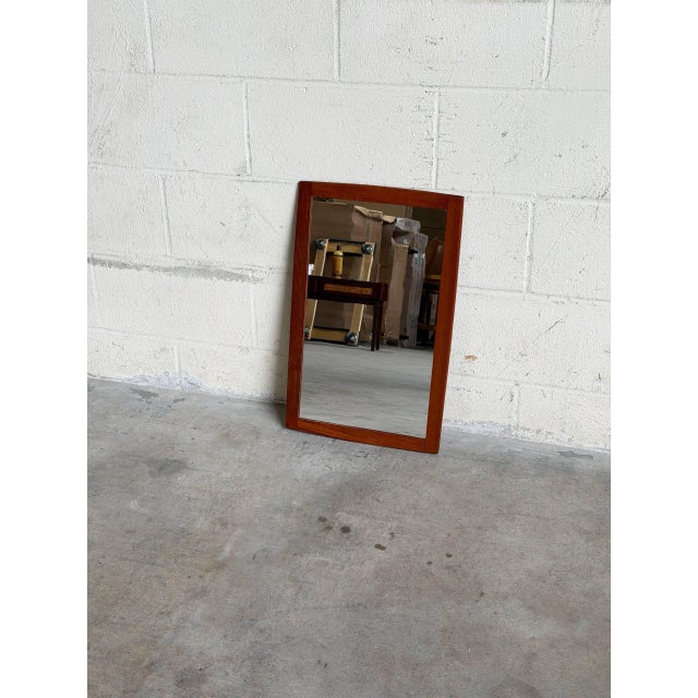 Vintage Danish modern wall mirror crafted in warm teak with a clean rectangular silhouette and beautifully balanced...
