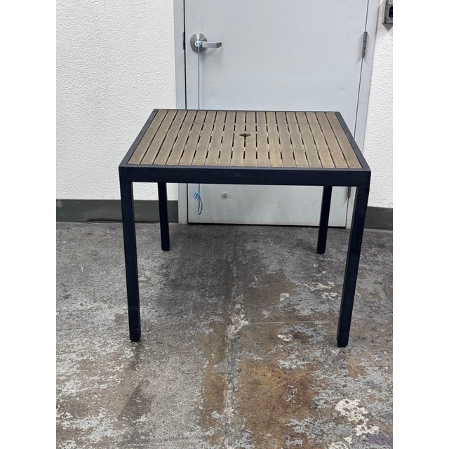 Design Plus Gallery presents the Crate & Barrel Alfresco Outdoor Dining Table. The table is designed with a black metal...