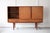 A striking Danish highboard in teak, designed by N. P. Neilsen for Sejling Skabe. The highboard has three sliding doors...