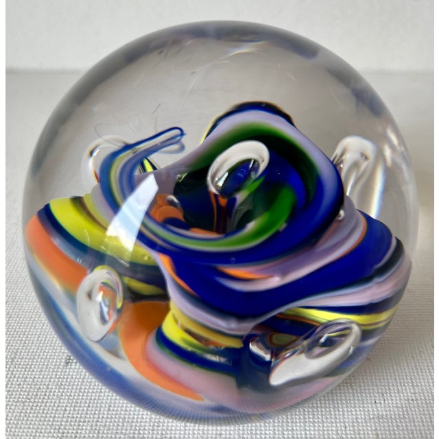 This beautiful hand-blown glass paper weight features jewel tone colors of Blue, Orange and Turquoise in a transparent...