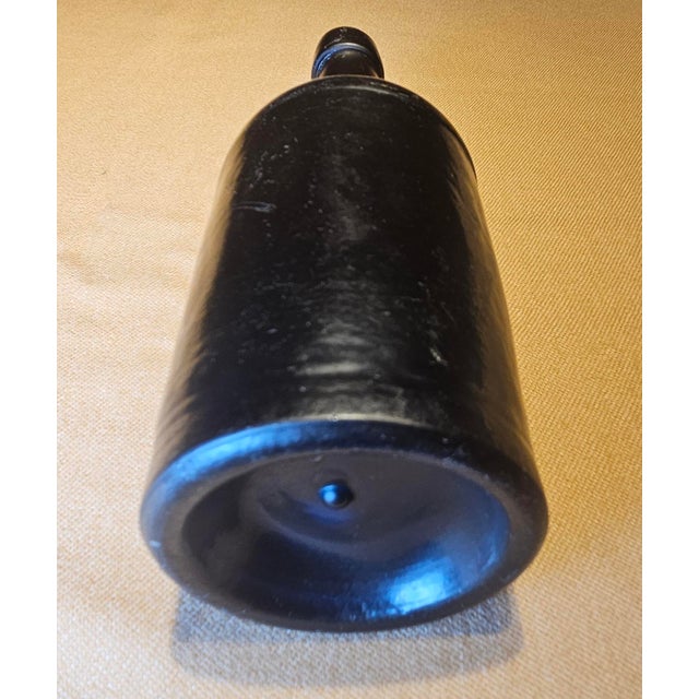 An exceptional and highly collectible authentic 1850s black glass bottle, showcasing the rich character and craftsmanship...