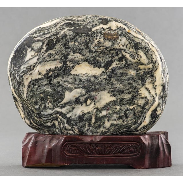 Chinese Natural Form Oval Dreamstone, with mountainous landscape, mounted on carved wood stand. 10.5" H x 10.5" W x 3" D....