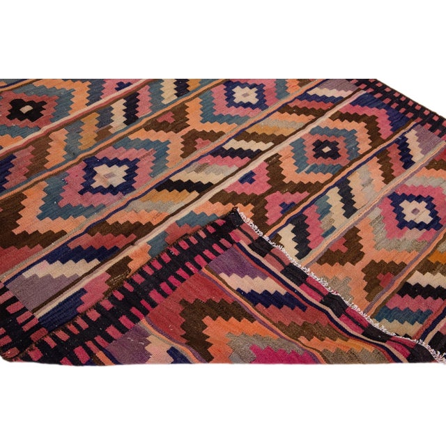 Beautiful vintage Turkish Kilim hand-knotted wool rug with a purple field. This piece has a black frame and multicolor...