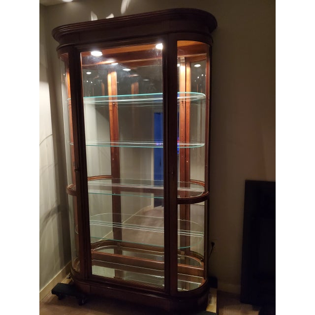 Pulaski Federal Style Curved-Side Illuminated Curio Cabinet Bring museum-quality display into your home with this late...