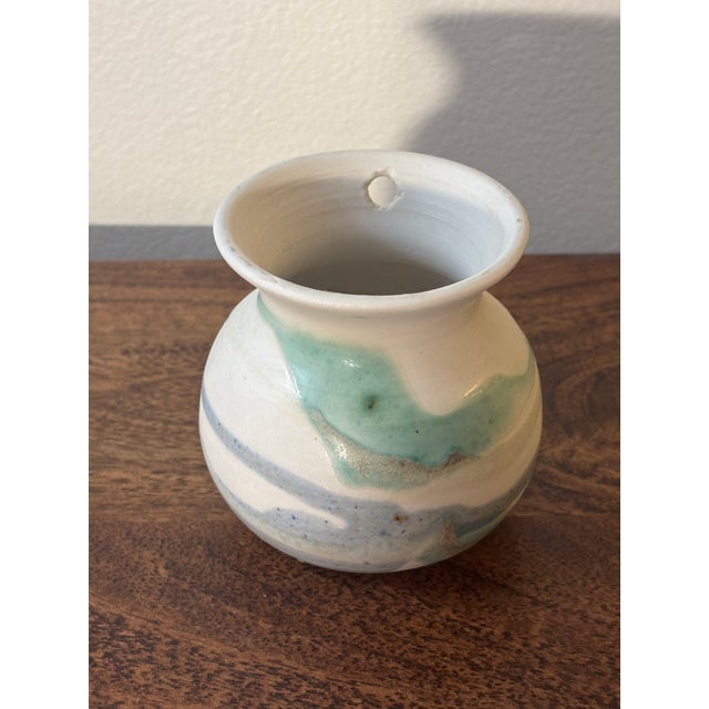 Attractive mid century modern studio vase. Petite stature with beautiful rolling curves. White base clay with varying blue...