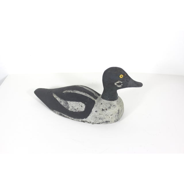 This is a vintage wood hunting decoy painted and shaped like a Goldeneye or Bufflehead duck. It features hand-painted...