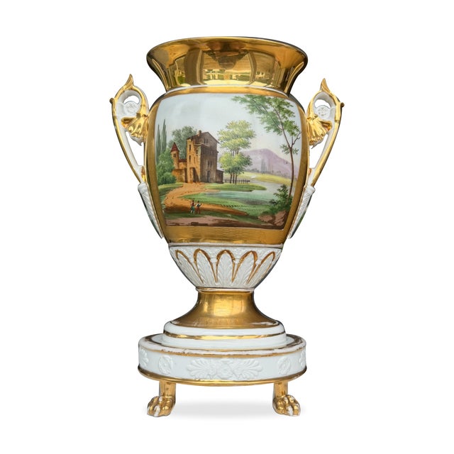 Two richly decorated porcelain vases combining painted Italianate landscapes with extensive gilding, openwork foliate...