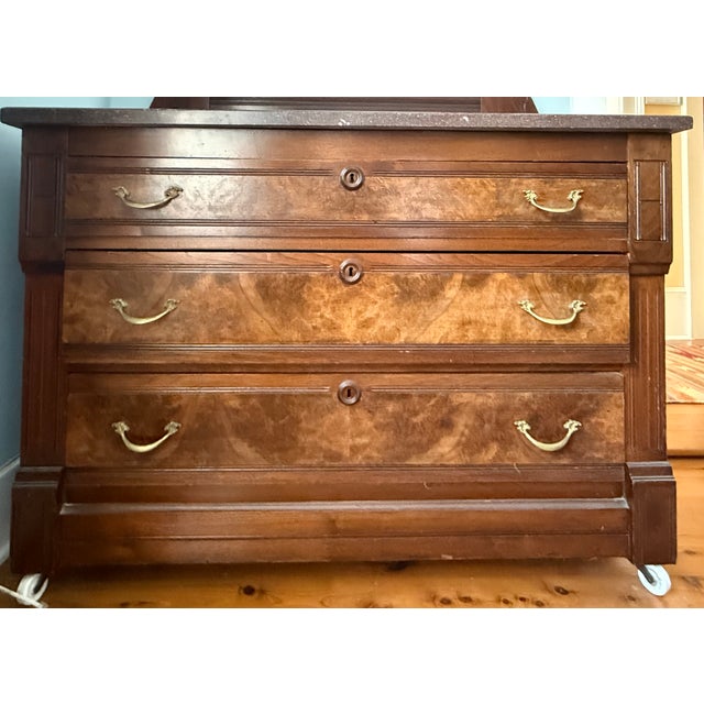 Victorian Eastlake dresser with mirror. This dresser has three drawers, and red/brown marble top, and a beveled mirror. It...