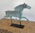 This sculptural piece is a vintage copper horse weather vane, artfully displayed on a modern black metal stand. The figure...