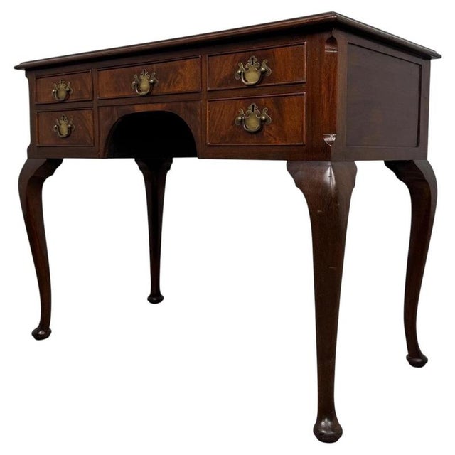 A handsome and finely crafted early 20th-century English Edwardian writing table, beautifully constructed in richly...