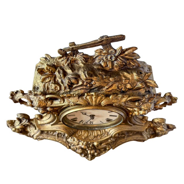 A striking antique Rococo Revival mantel clock featuring an ornate cast metal case with flowing acanthus scrollwork,...