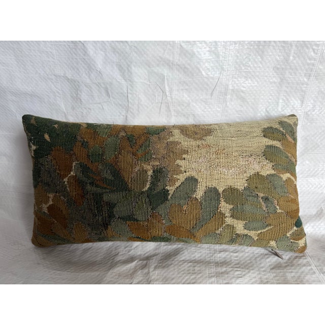 A 17th century Brussels tapestry pillow showcasing a classic Flemish botanical motif rendered in a softened, time-worn...