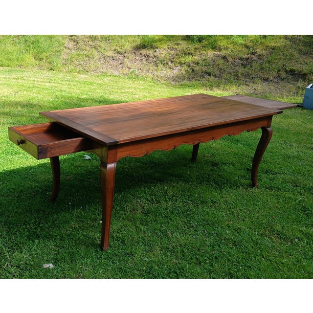 Early 20th-century Louis XV style cherrywood farmhouse table. The apron is pegged and features a large drawer on the side....