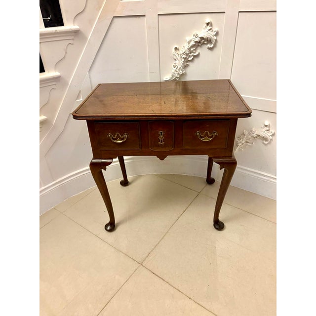 A lovely Georgian-style oak lowboy with a well-figured rectangular top, three drawers fitted with original brass swan-neck...