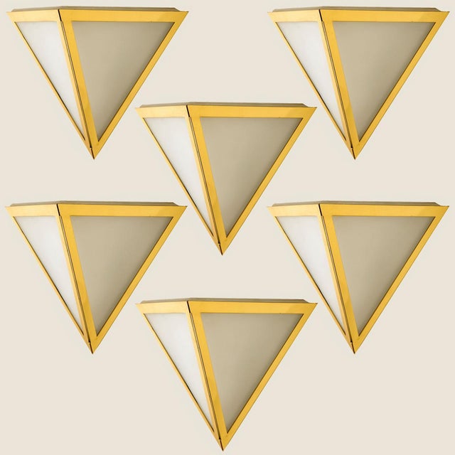 Triangular wall lights in white opaline glass with brass details. Manufactured by Glashütte Limburg in Germany during the...