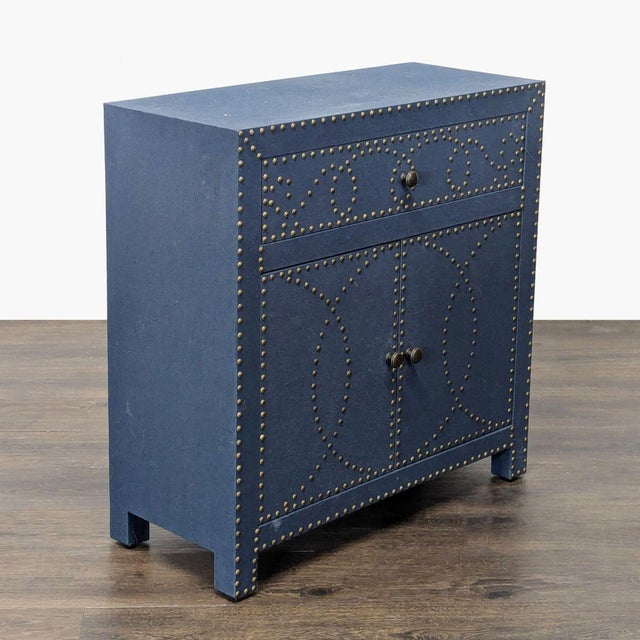 Double-door one drawer cabinet with interior shelf, covered in navy-toned linen with nailhead trim. Brand: Bungalow Rose....