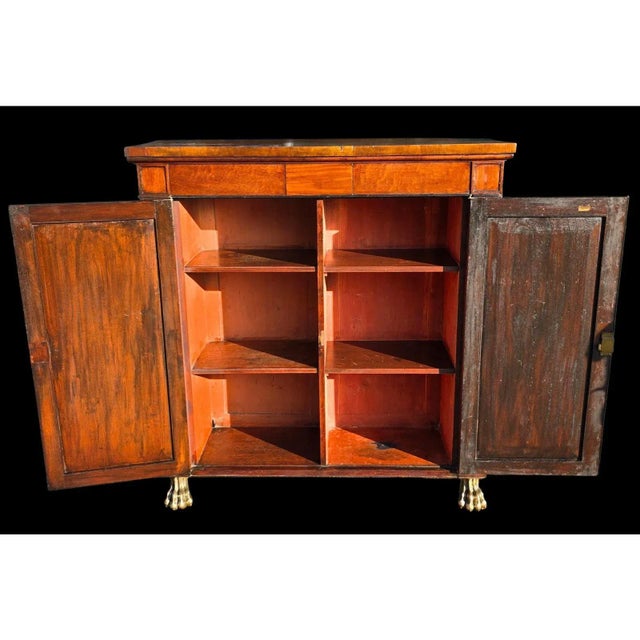 This Early 19th Century Regency-Style Mahogany Side Cupboard is a gorgeous and refined piece with elegant grace and...