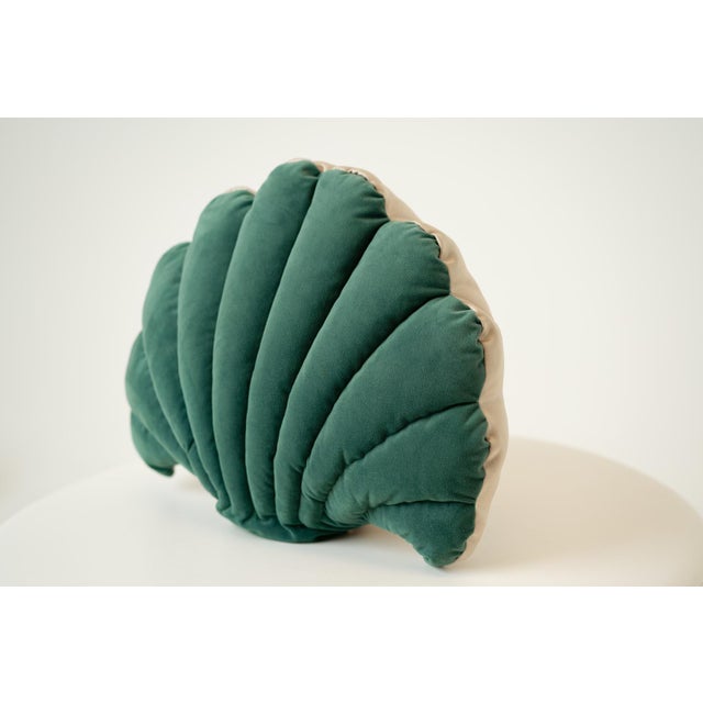 Whimsical and sculptural, this seashell-shaped throw pillow in deep green brings coastal charm and playful artistry to any...