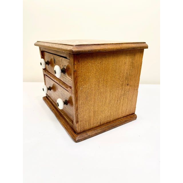 Antique two-drawer oak spool cabinet - possibly hand crafted. Traditionally used in general stores or homes to organize...