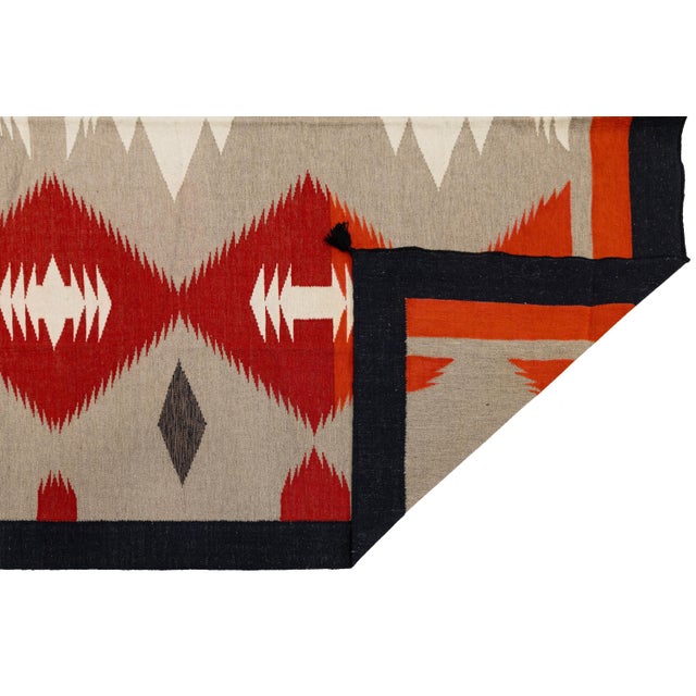 Elevate high-end interiors with this hand-woven Navajo-inspired wool flat-weave rug. Featuring striking serrated diamond...