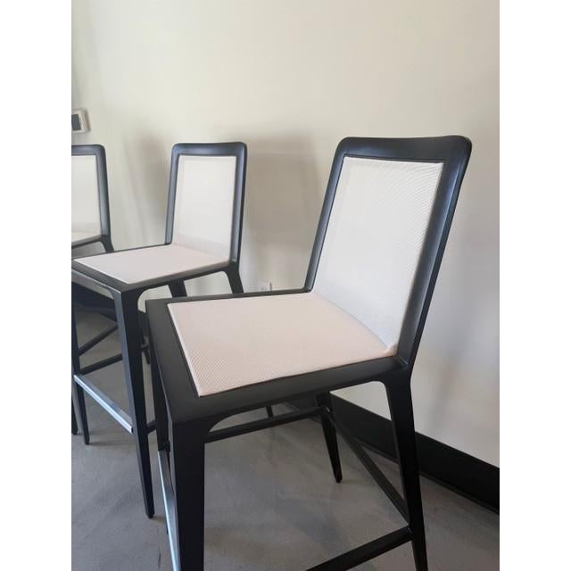 Set of three Still bar stools designed by Richard Frinier for Brown Jordan, finished in Night with Salt Air mesh. The...