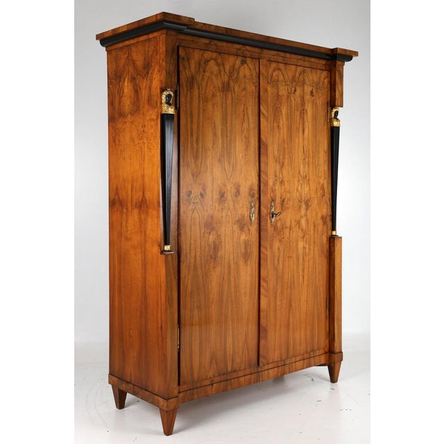 Original impressive closet in walnut veneer , 2 parts , a so-called spandrel , the wardrobe is wedged in the middle at the...
