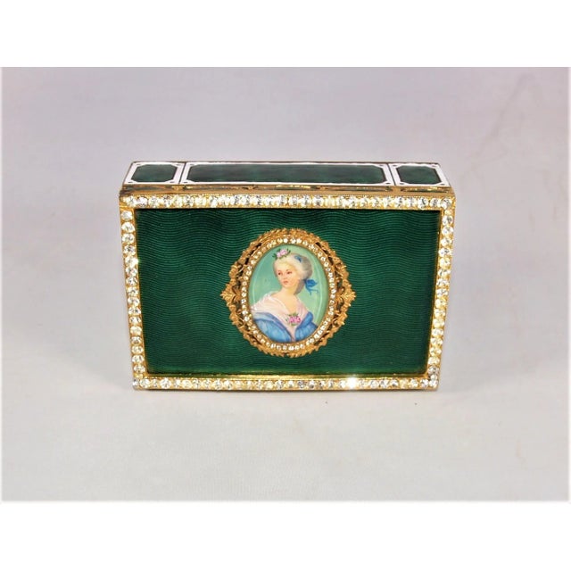A vintage gold-plated hinged trinket box with a miniature painting of a woman. Dates to early 1900’s. Painting is nicely...