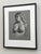 This artwork presents a striking figure study rendered in charcoal and pastel, showcasing a contemplative pose that...
