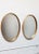 Pair of wide, oval-form Labarge mirrors composed of inset glass within deep, gold leaf frames. There is minor wear to the...