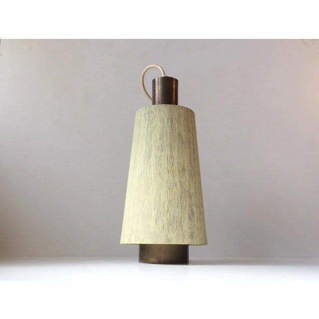 This vintage pendant light is made of brass and decorated with a textured light green paint to the external shade. It was...