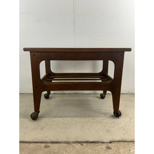This mid century modern accent table features hardwood construction, durable black lacquer top, slat shelf underneath and...