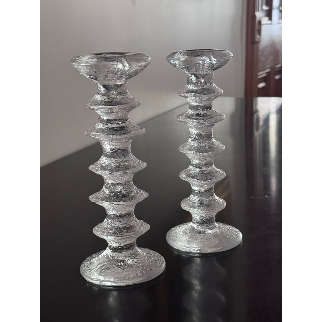 The Festivo candleholders were designed by Timo Sarpaneva for Iittala in 1966. The striking glass objects feature an ice-...