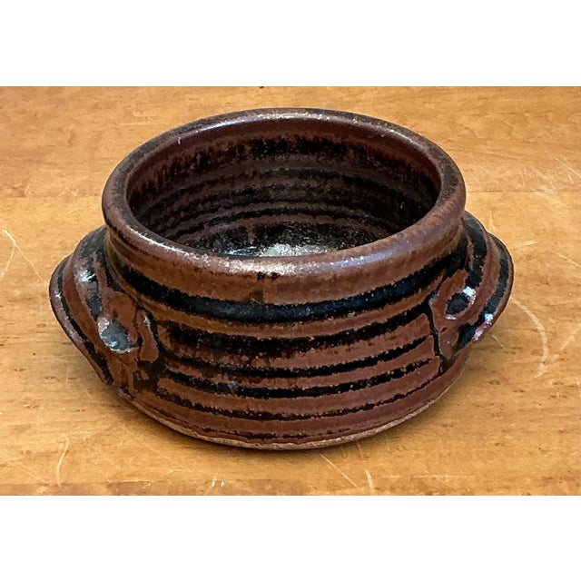 Celebrate the beauty of handcrafted pottery with this vintage striped stoneware bowl, a charming decorative vessel that...