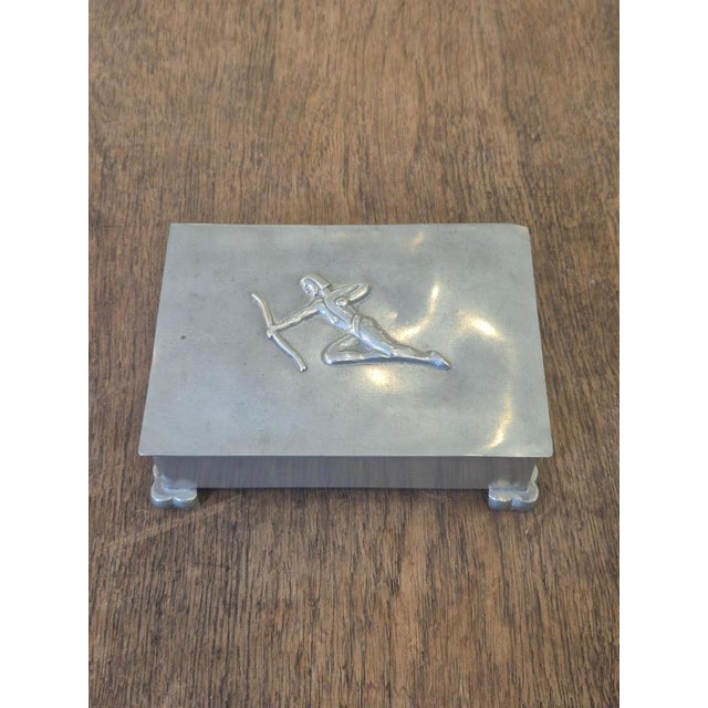 A decorative and functional lid box, perfect for jewelry, cigarettes or hiding away smaller items. Decor of archer. with...