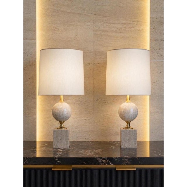 A striking and highly refined pair of travertine table lamps designed by philippe barbier for maison barbier, embodying...