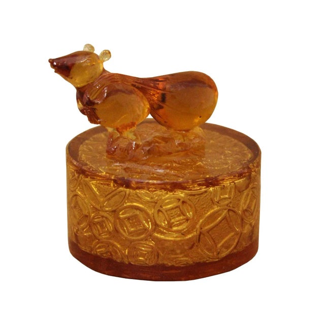 This charming perfume bottle features a playful rat, the symbol of the first animal in the Chinese zodiac, pulling along a...