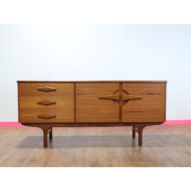 Discover the beautifully compact Mid Century Modern Vintage Teak Sideboard Credenza in the style of British furniture...