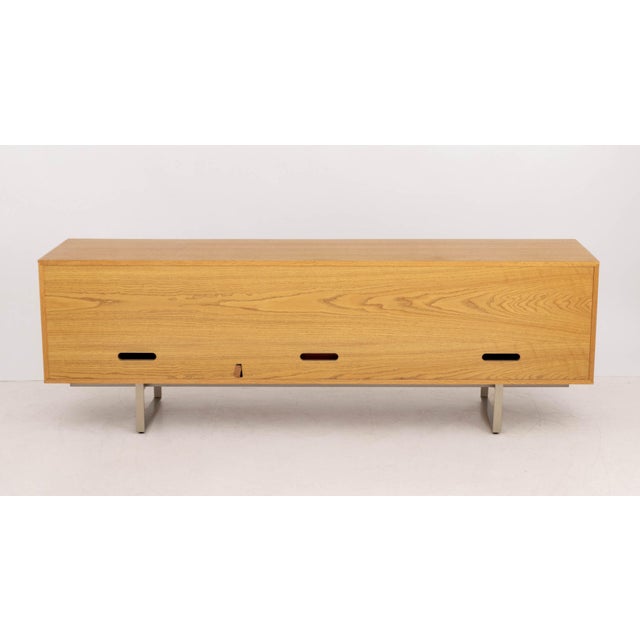 Blu Dot Series 11 White Oak Sideboard, with two central drawers flanked by two cabinets mounted on chrome-plated base....