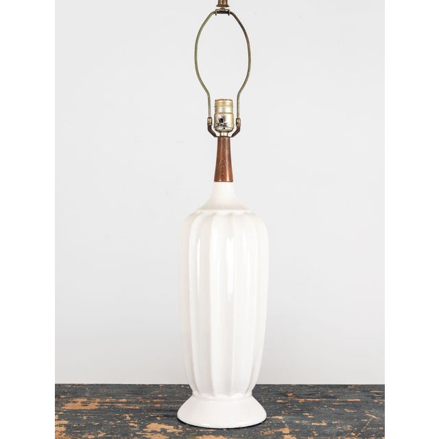 This elegant 1960s-era vintage table lamp features a fluted white ceramic body with a gently tapered shape, widening...