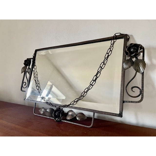 Rectangular mirror from the early 20th century Beveled wrought iron mirror suspended by a chain Decorated with metal...