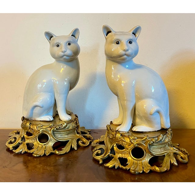 Pair antique 19th century Japanese blanc de Chine models of seated cats mounted on French ormolu bases. Mirroring each...