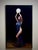 This oil on linen artwork features a figure draped in flowing fabric, gracefully raising a luminous orb above her head...