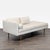 This West Elm chaise sofa features a modern design with clean lines, light beige upholstery, and warm wooden legs. It...