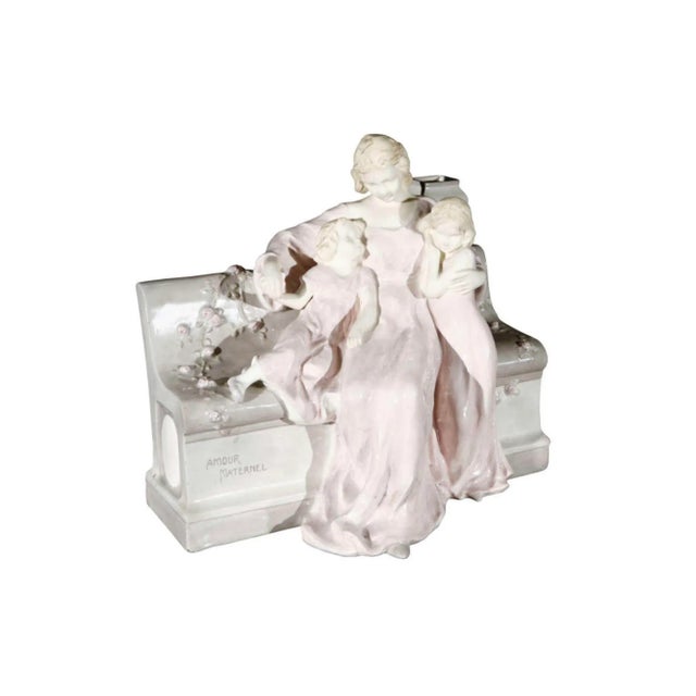 A Vienna faience porcelain figurine representing Motherly Love by Schauer. Bench and figures are porcelain. Faces and arms...