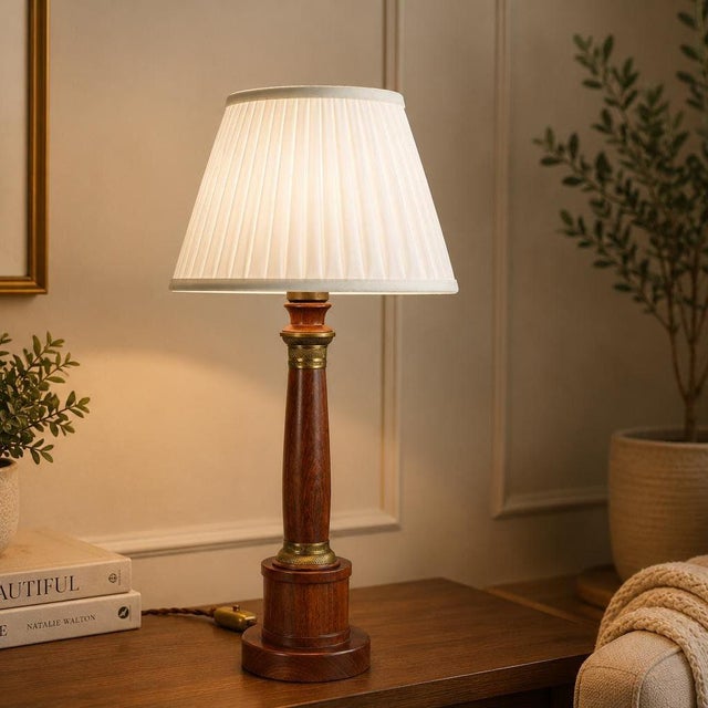 Neoclassical column table lamp dating to the 1950s, made from turned hardwood with a warm reddish-brown finish and visible...