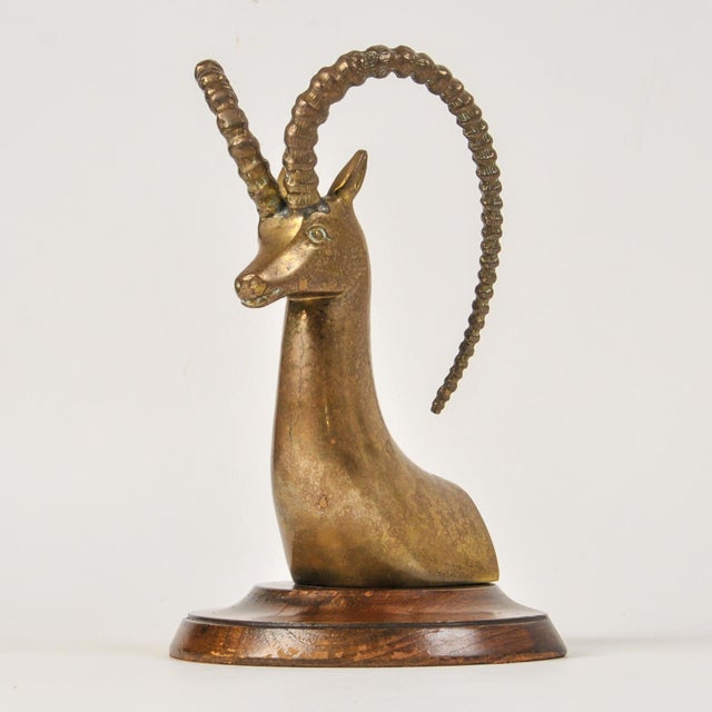 An incredible large brass gazelle or ibex bookend mounted on a wooden base. This stately long horn piece is a classing mid...