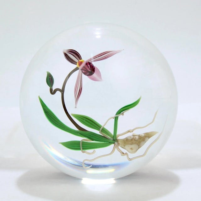 A very fine studio glass paperweight by Chris Buzzini. With a lampwork orchid (including the roots). With a signature cane...